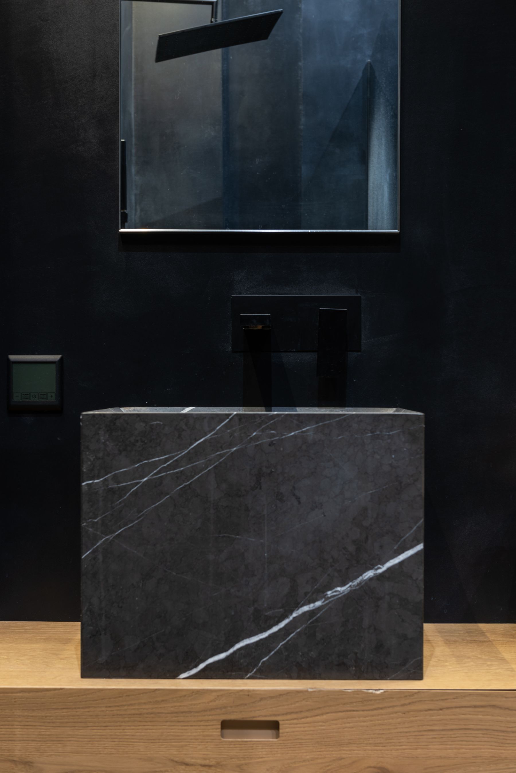 Dark marble sink against lighter bathroom finishes