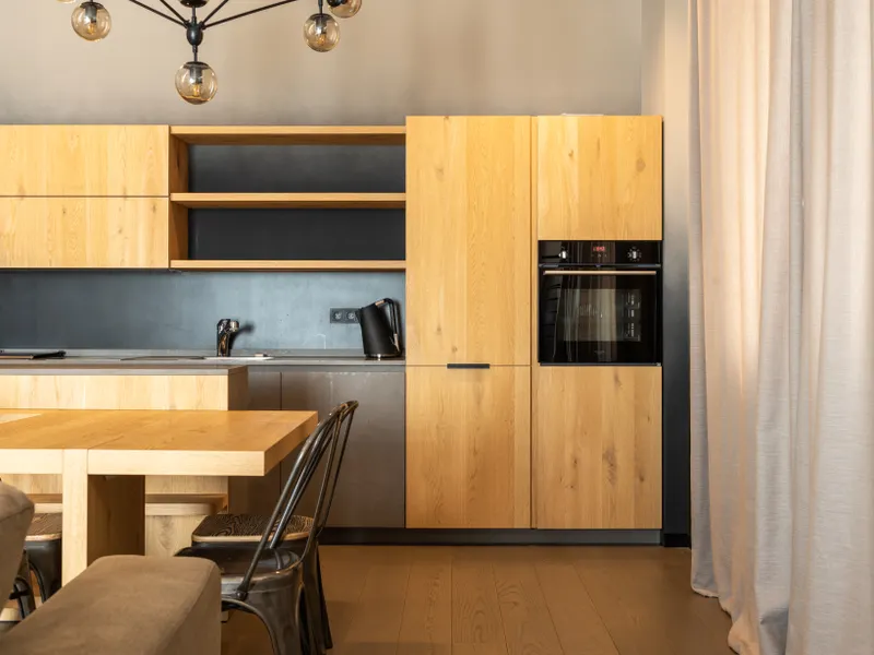 Stylish kitchen with a wooden table, cupboards and modern appliances Stylish kitchen with a wooden table, cupboards and modern appliances