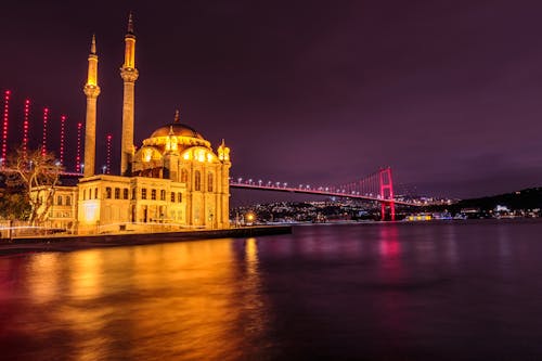 Mosque Near the Bridge Illuminated during Night Time