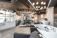 Backwash chairs with sinks placed in spacious modern beauty salon with stylish design and various cosmetology products with professional equipment