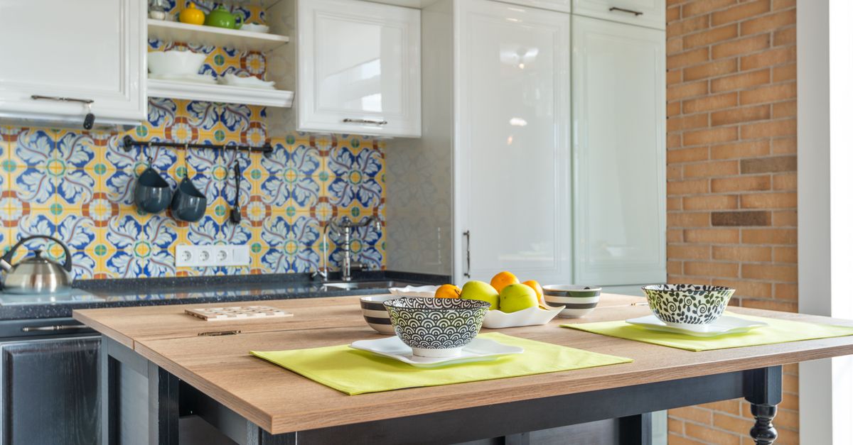 Stylish contemporary kitchen with vibrant printed tiles, wooden tabletop, and elegant interior.