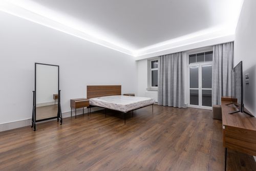 Free Elegant and spacious minimalist bedroom with wood flooring and contemporary furnishings. Stock Photo
