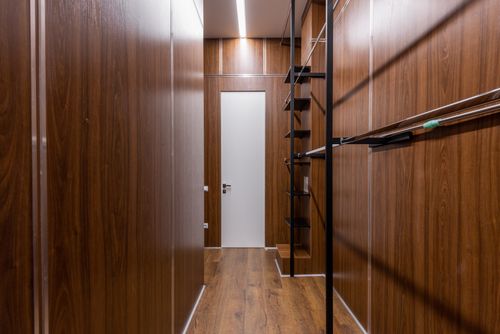 Free Empty black shelves and racks placed near brown walls in corridor with minimalist style with white door and glowing illumination Stock Photo