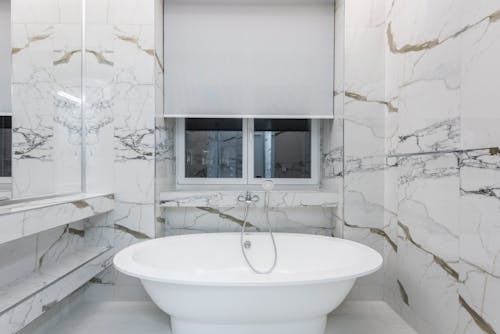 White Ceramic Bathtub in a White Patterned Wall Tiles
