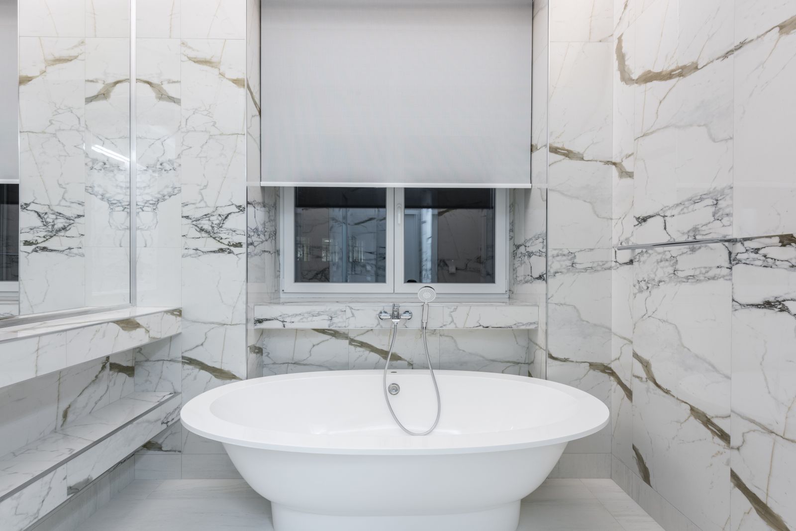 Modern luxury bathroom with marble tiles and freestanding bathtub