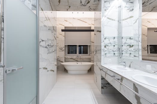 Elegant modern bathroom featuring marble decor with a freestanding bathtub.