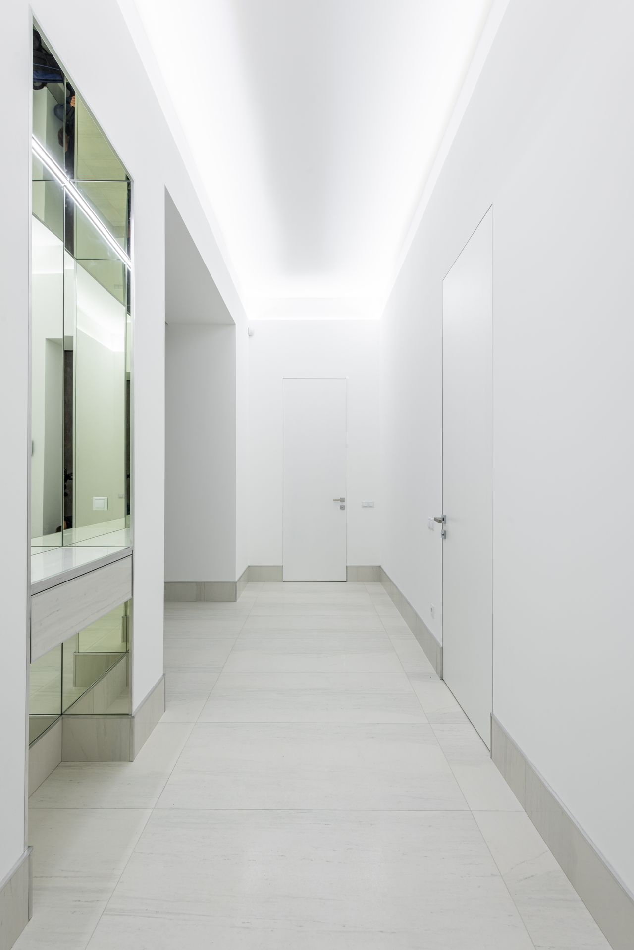 White minimalist corridor with flush-panel interior doors
