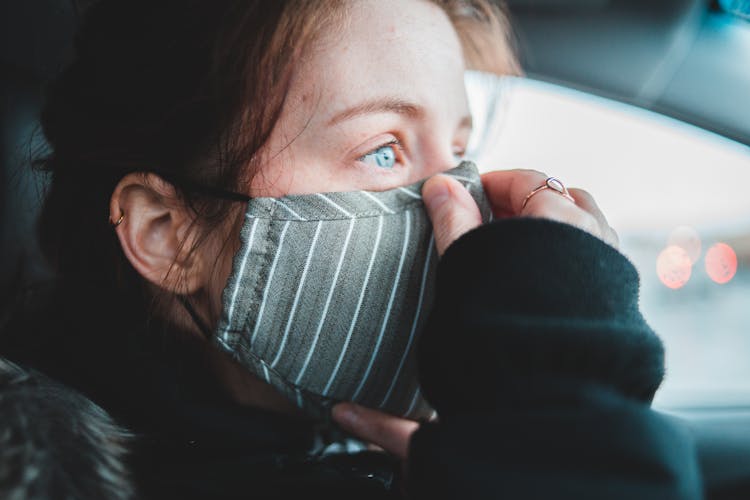 Woman Putting On Protective Mask In Car