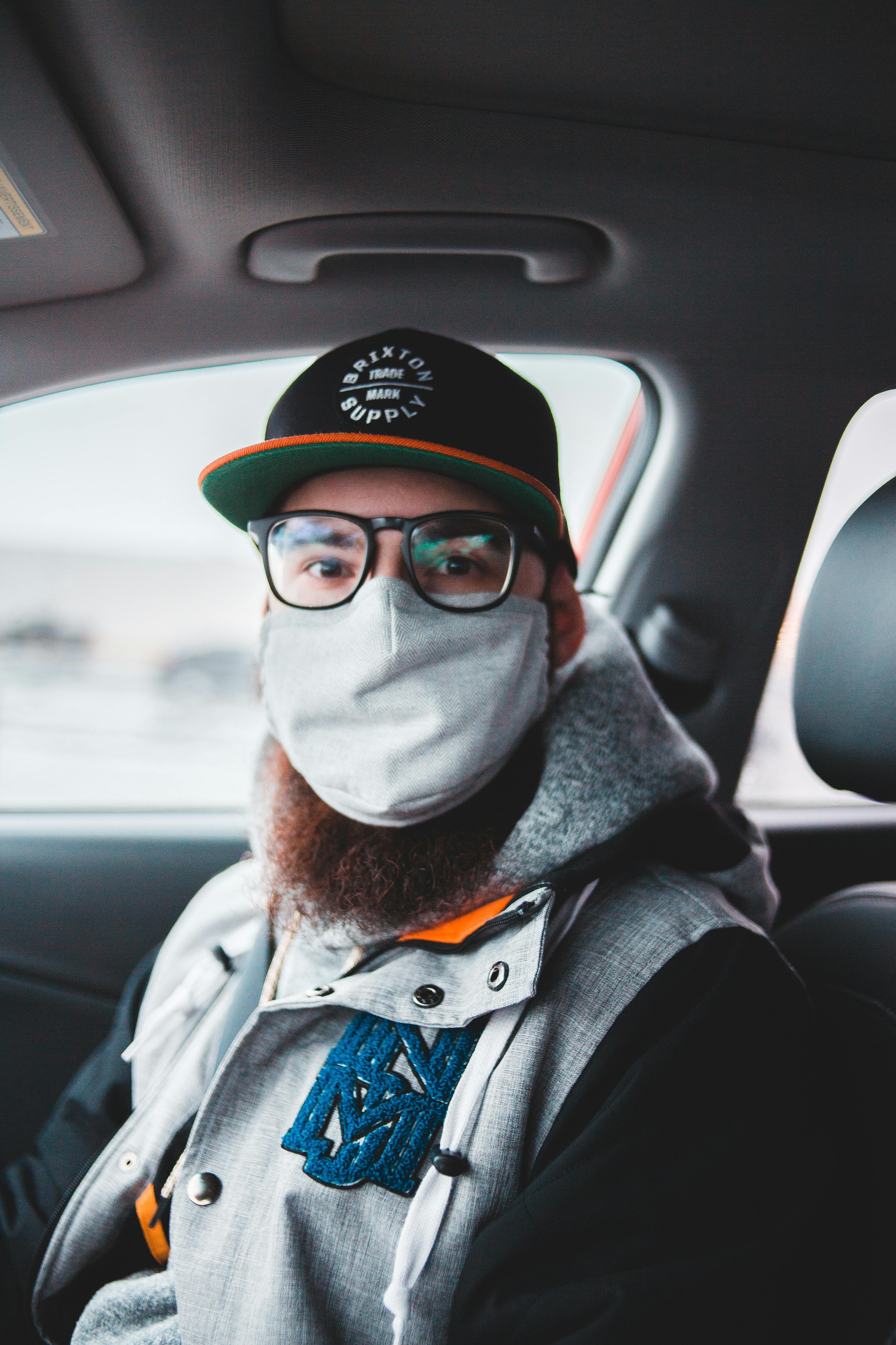 Man with beard wearing protective mask in car · Free Stock Photo
