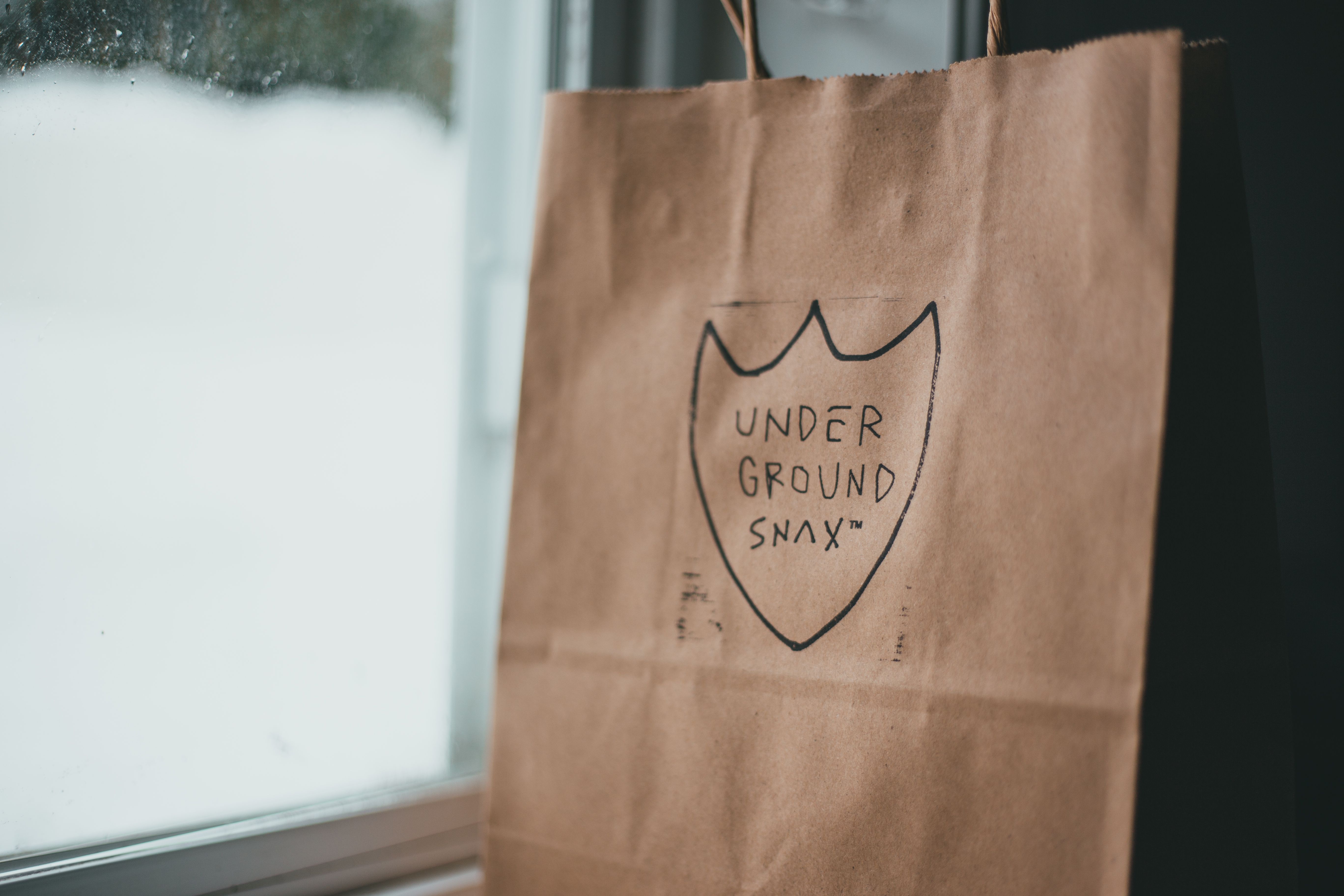 Paper packet with picture and inscription placed near wet window on daylight in snowy winter