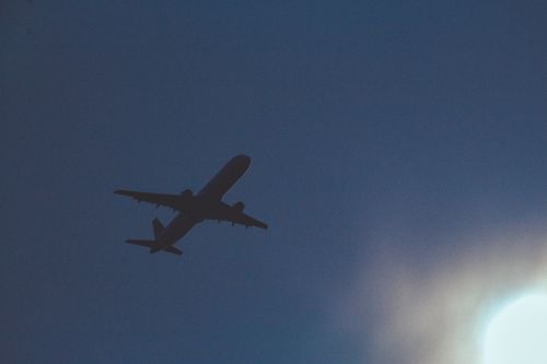 Free A dark silhouette of an airplane flying in the blue sky during twilight. Stock Photo