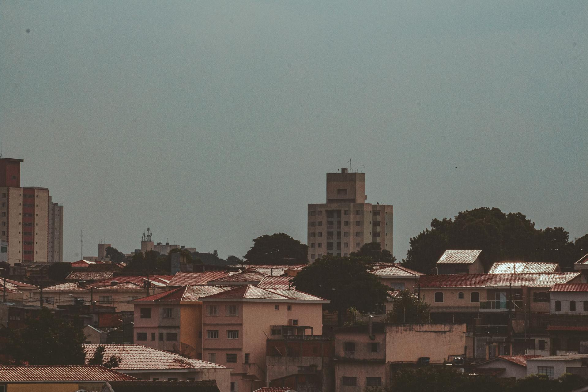 A scenic urban cityscape featuring various residential and commercial buildings under a clear sky.