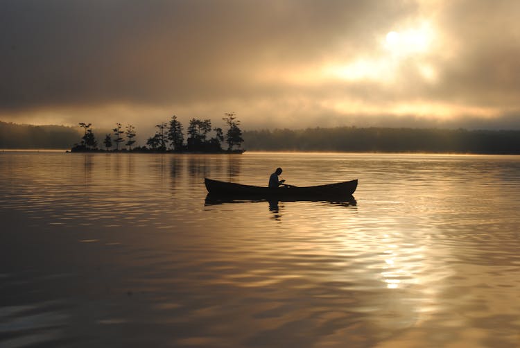 
A Silhouette Of A Person On A Canoe