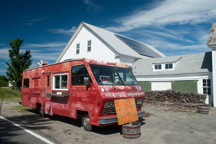 An Old Camper Van Standing In Front Of A House 