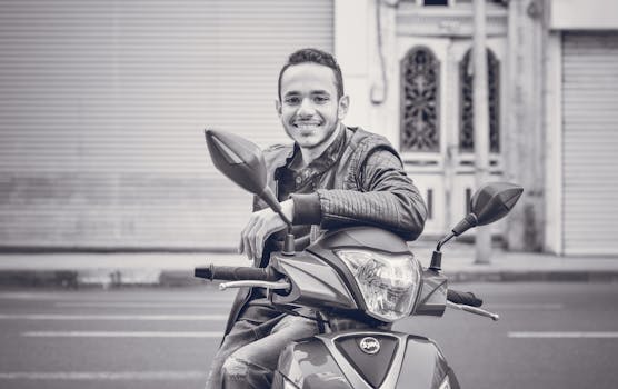 一名年轻人坐在滑板车上，在城市街道上微笑