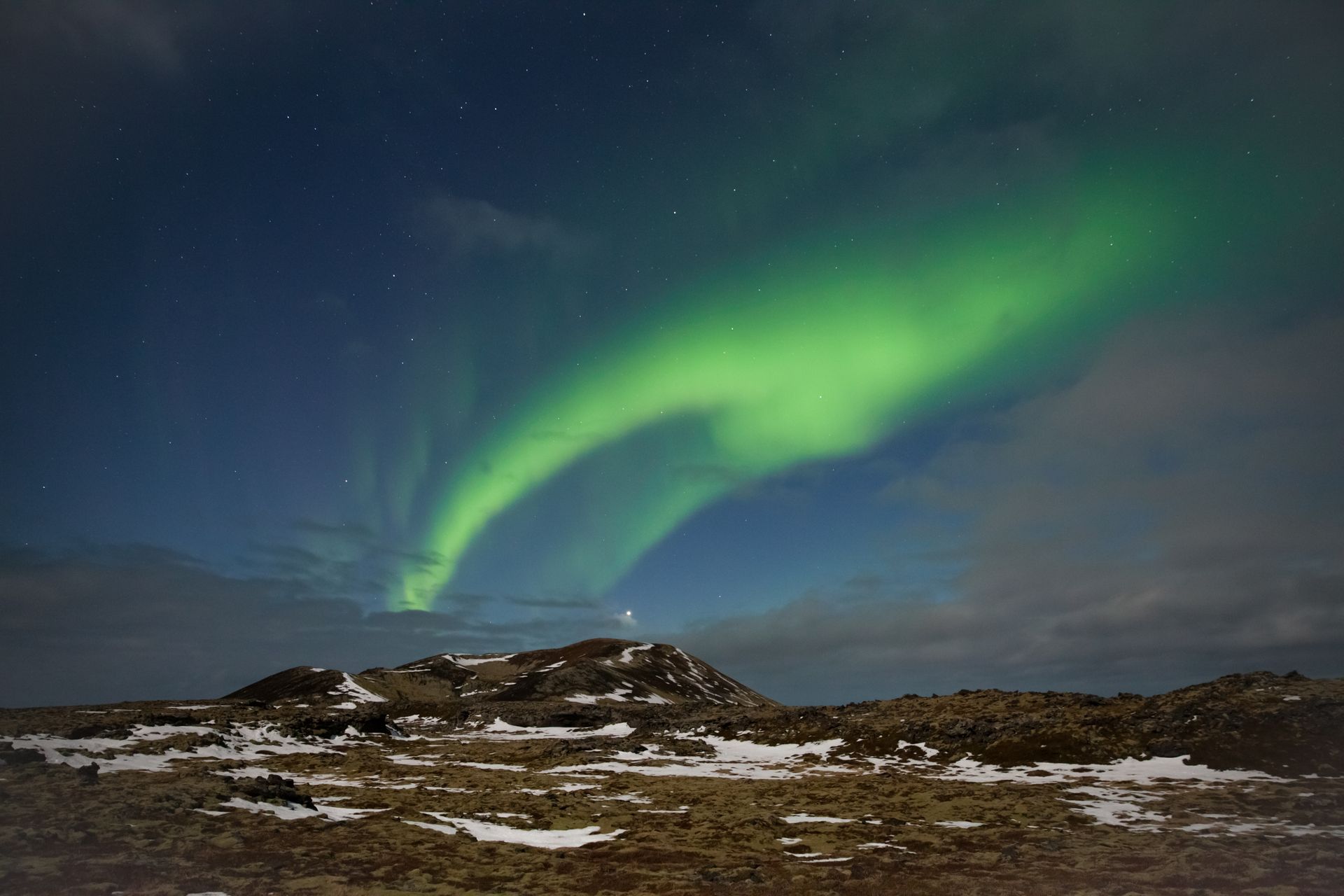 Enchanting aurora borealis illuminating the sky over snowy Icelandic terrain. Breathtaking night landscape.