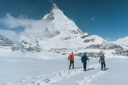 People Hiking on Snow Covered Mountain