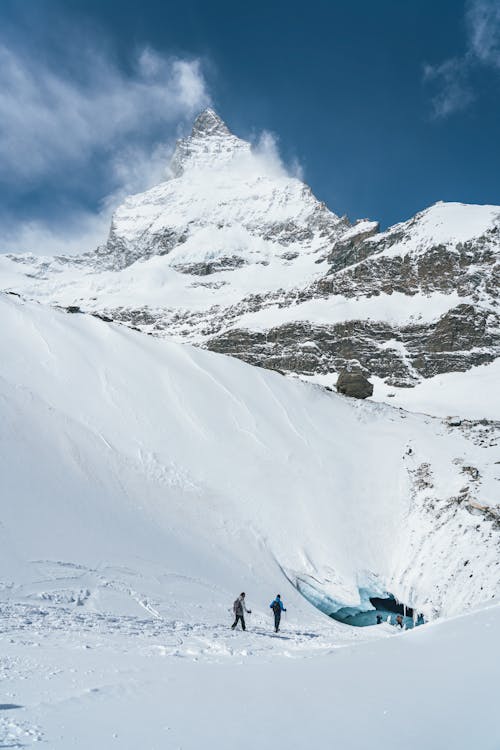 Hikers Walking on Snow Covered Mountain Top