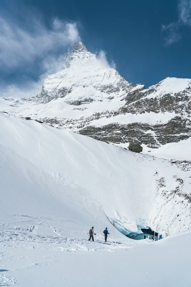 Hikers Walking On Snow Covered Mountain Top