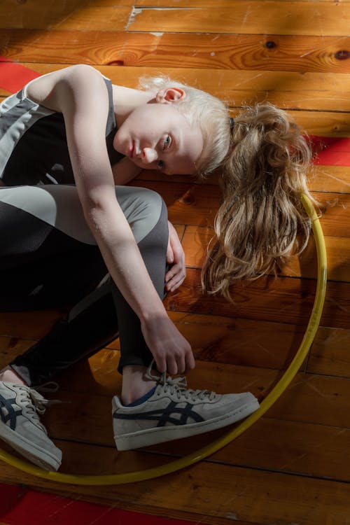 A Young Girl Lying Down on Wooden Flooring