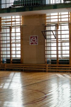 A spacious sports hall with wooden floor and ample natural light.
