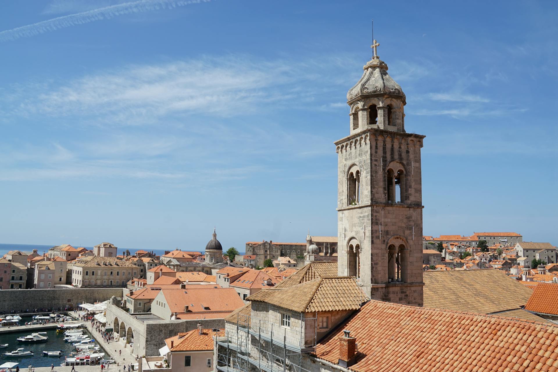 View of the ancient bell tower and the historic townscape of Dubrovnik under a clear sky.