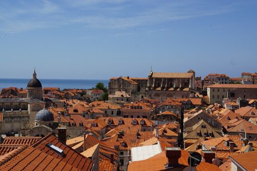 Free Aerial view of Dubrovnik's historic red rooftops against a clear blue sky and the Adriatic Sea. Stock Photo