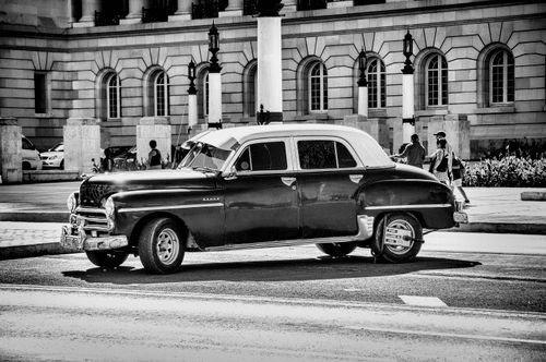 Free Classic vintage car parked in front of a historic building in Camaguey, Cuba. Stock Photo
