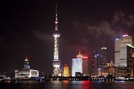 夜幕下的上海浦东，东方明珠塔灯火通明，倒映在黄浦江上