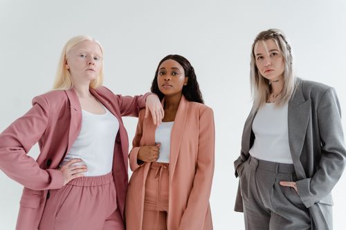 Free Three diverse women in trendy business suits pose confidently against a white background. Stock Photo
