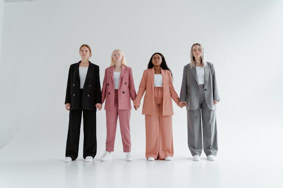 Women in Blazer and Pants Standing while Holding Hands