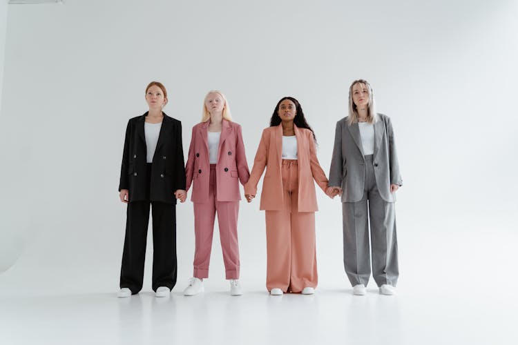 Women In Blazer And Pants Standing While Holding Hands