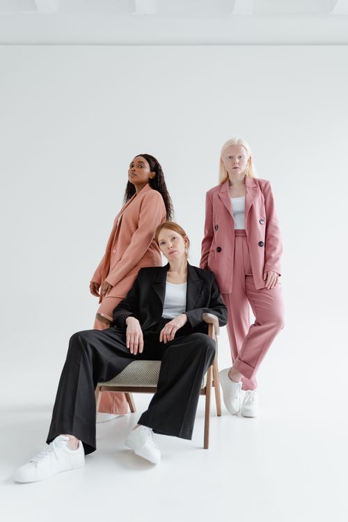 Free Three diverse women in stylish business suits pose confidently against a white background. Stock Photo