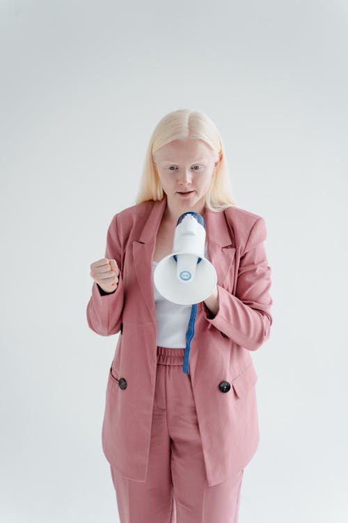 Free A Woman in Pink Blazer Talking while Holding a Megaphone Stock Photo