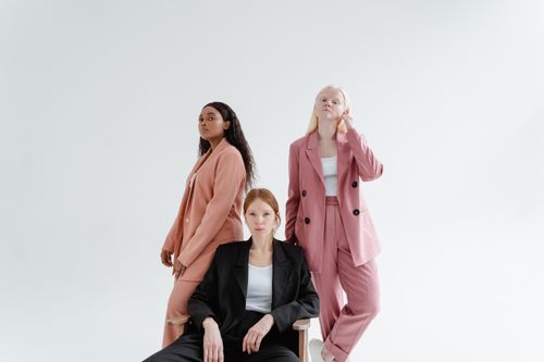 Free Three diverse businesswomen in stylish suits on a studio white background, exuding confidence. Stock Photo