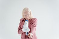 Woman in Pink Blazer Holding White Ceramic Mug