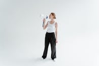A Woman in White Tank Top and Black Pants Holding a Megaphone