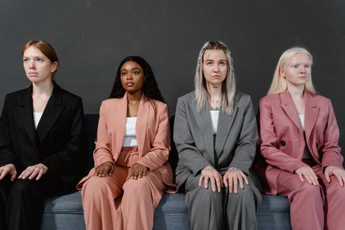 Free Group of diverse women in modern business suits sitting in a studio setting. Stock Photo