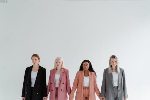 Women Wearing Business Attire Standing on White Background