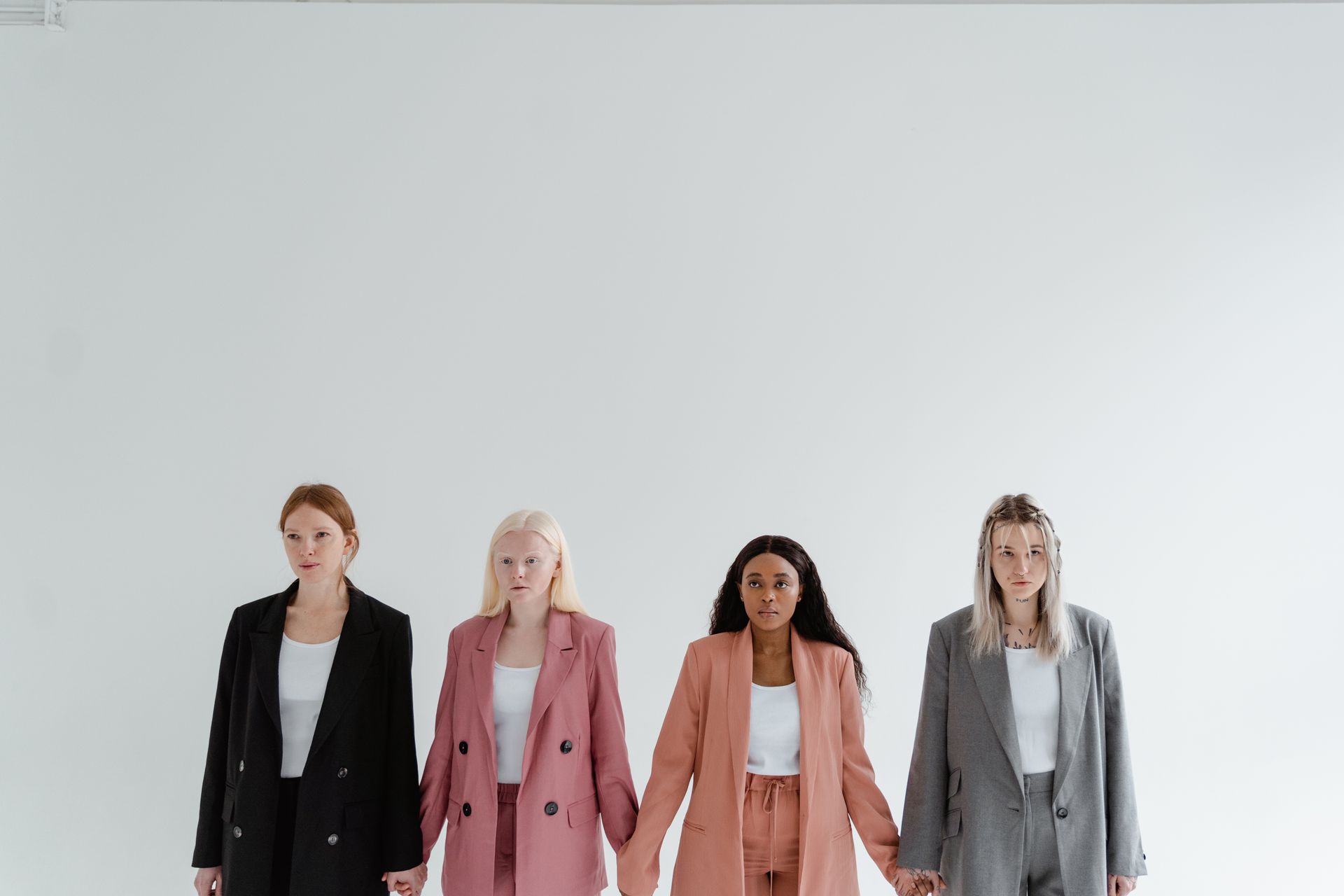 Four diverse women standing in corporate attire, symbolizing unity and empowerment.