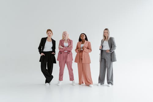 Women in Blazers and Pants Posing in White Background 