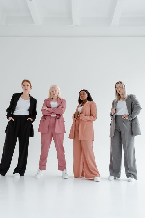 Free A group of confident businesswomen posing in colorful suits on a white background. Stock Photo