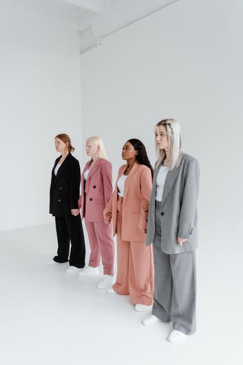 Free Four women in stylish suits standing in studio, showcasing diversity and fashion. Stock Photo