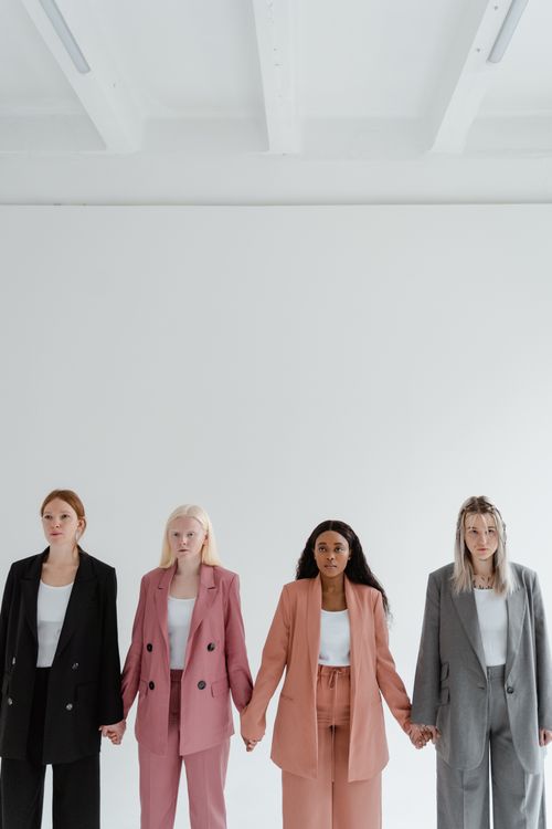 Free Four diverse women in business attire standing together in a studio. Stock Photo
