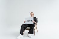 Woman Sitting on a Chair Holding a Sign Board