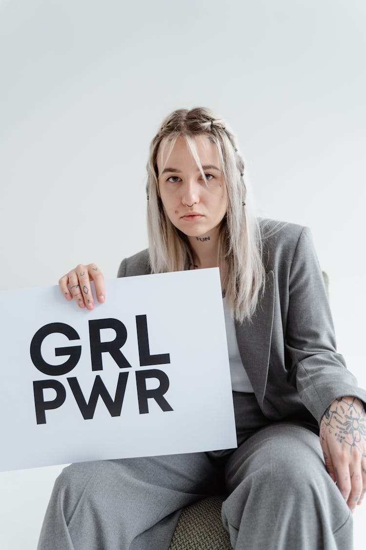 Woman In Gray Blazer And Pants Holding A Girl Power Postcard