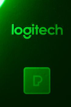 Close-up of a Logitech logo with green lighting against a dark background for tech branding. 7202944