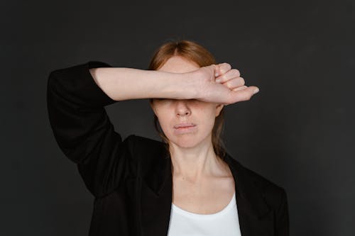 Woman in Black Blazer Covering Her Eyes With Her Hand