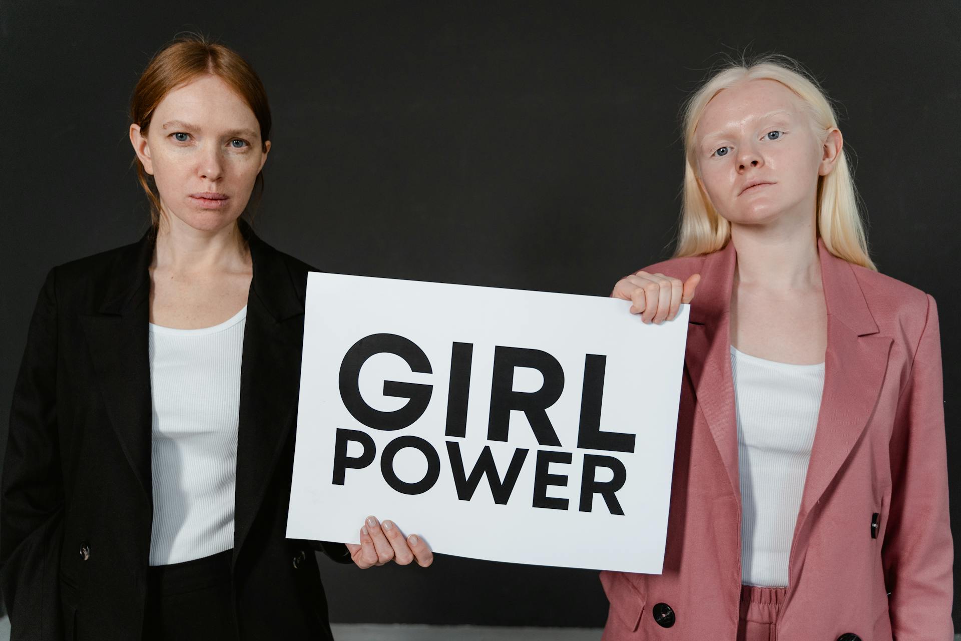 Women in Pink and Black Blazer Holding a Girl Power Postcard