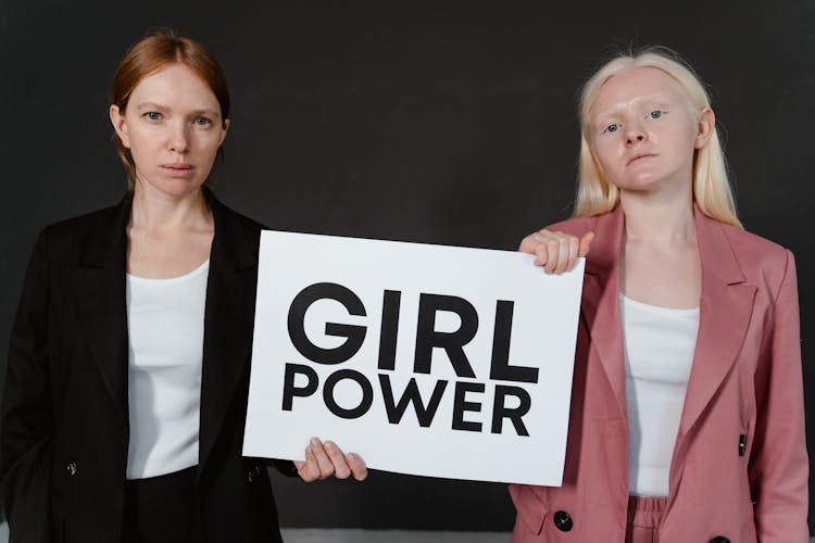 Women In Pink And Black Blazer Holding A Girl Power Postcard